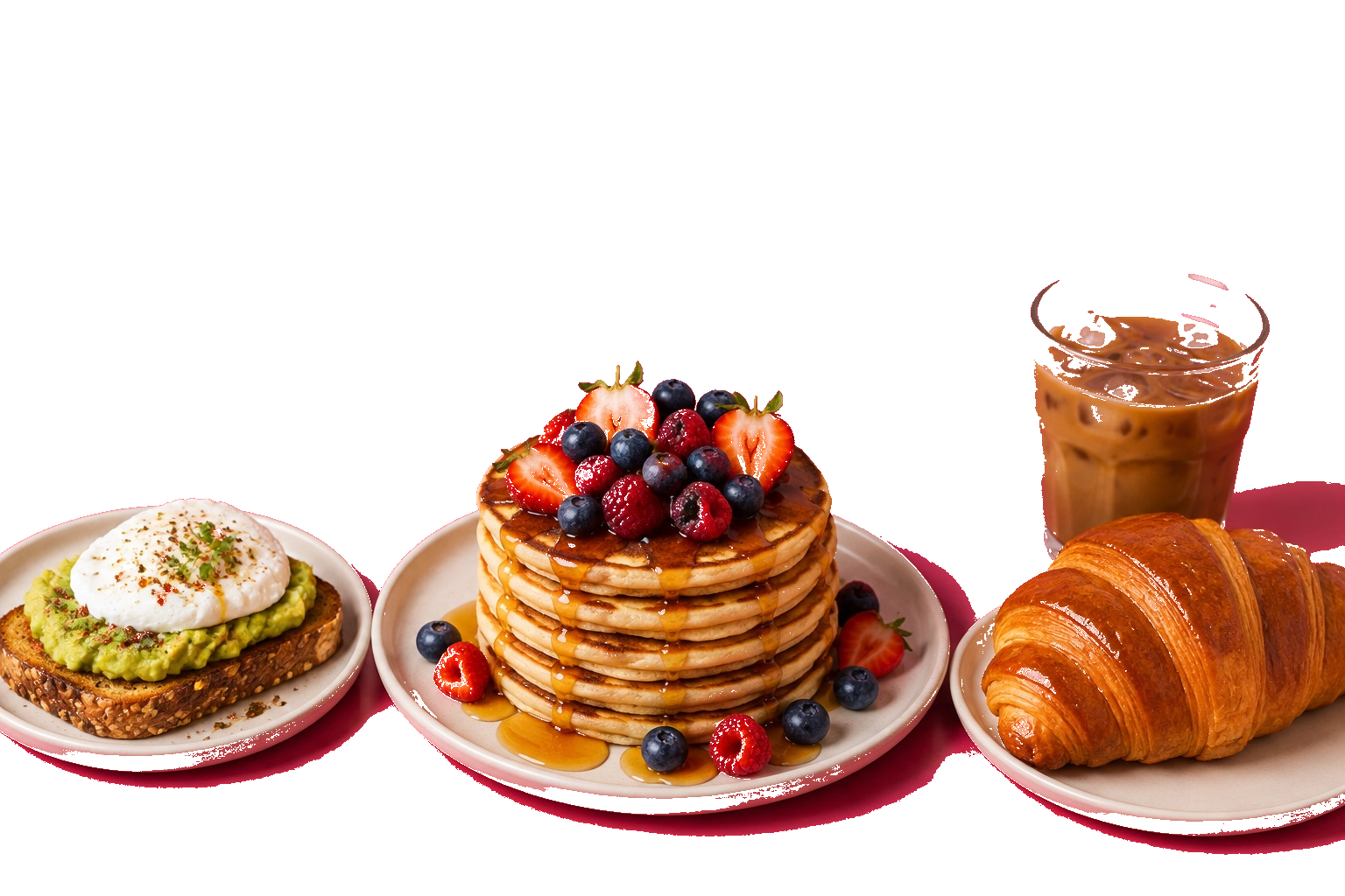 Pancakes généreux aux fruits rouges et sirop, tartine d’avocat avec œuf poché, croissant doré et café glacé sur une table.